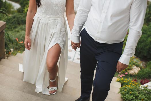Bride and groom walking together holding their hands