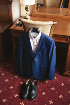 Blue men's suit and black groom 's shoes.