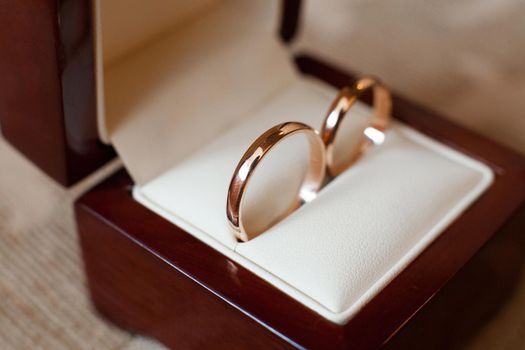 Elegant gold wedding rings in a wooden box