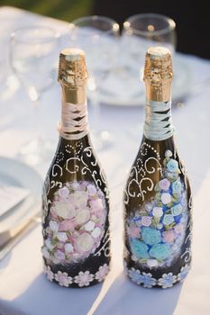 Decoration of a bottle of champagne and sparkling wine on table. Wedding decor