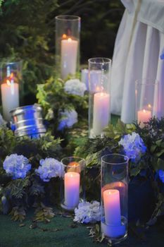 Arrangement of flowers, candles and green plants.