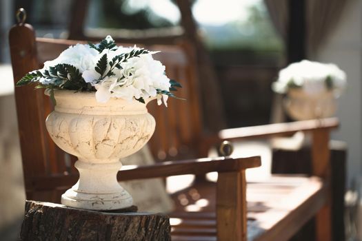 Flowers in a stone vase at a wedding ceremony