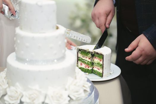 The bride and groom cut a gorgeous wedding cake at a banquet