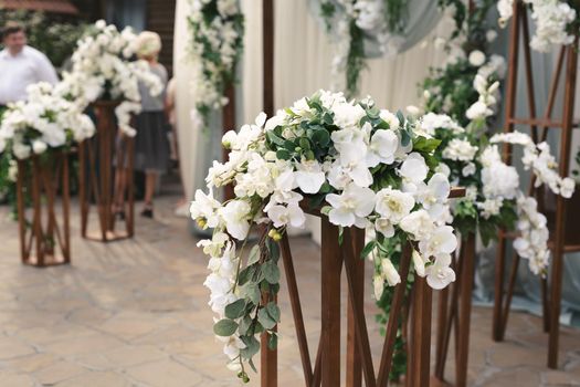 Details. Wedding ceremony in the open air of fresh flowers, with candles. Gentle and beautiful wedding decor for newlyweds