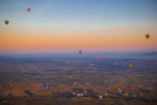 GOREME, CAPPODOCIA TURKEY - SEPTEMBER 18, 2021 - Hot air balloon flying over rocky landscapes in Cappadocia Turkey