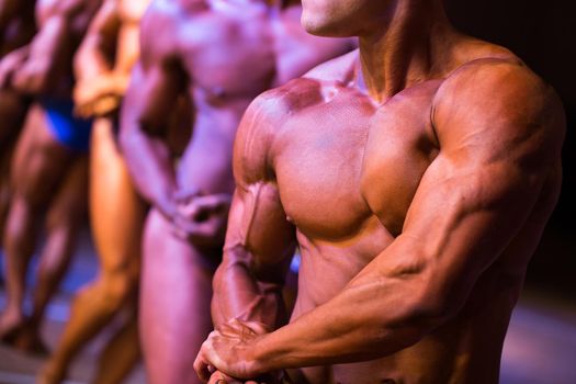 athletes bodybuilders are straining biceps side of arm.