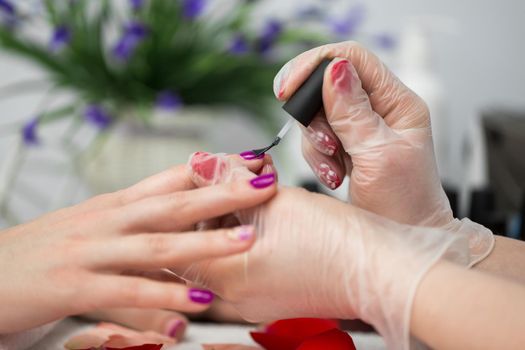 Manicure pink nail polish in the salon.