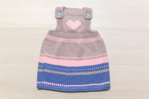 Knitted wool dress for a child on a white background.