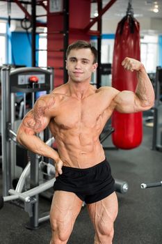 Bodybuilder posing for the camera in the gym.