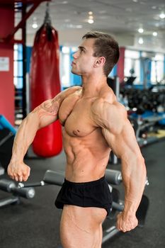 Bodybuilder posing for the camera in the gym.
