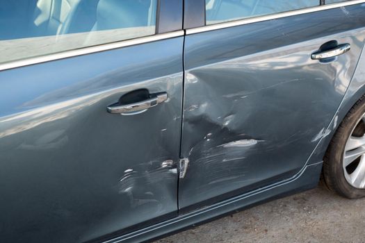 Sheet metal damage on a blue car after an accident.