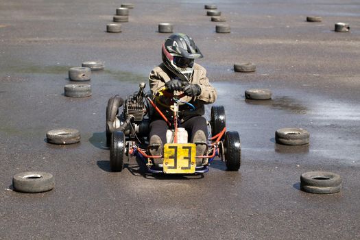 Karting - driver in helmet on kart circuit.