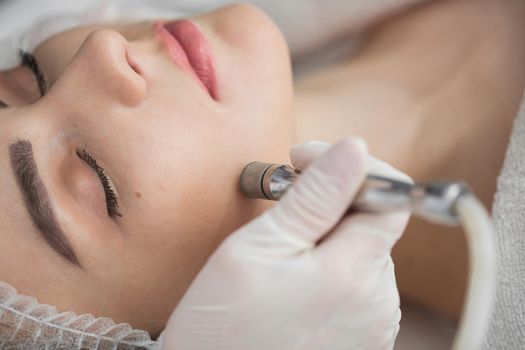 Diamond microdermabrasion, peeling cosmetic. woman during a microdermabrasion treatment in beauty salon.
