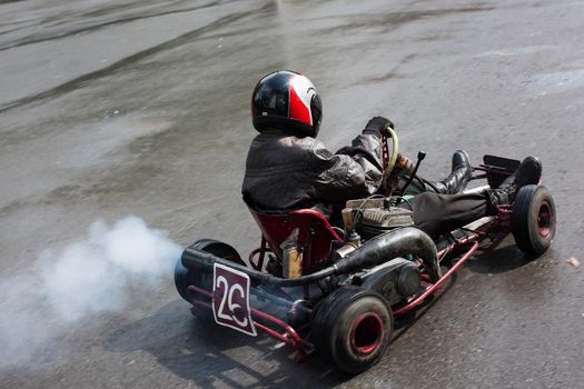 Karting - driver in helmet on kart circuit.