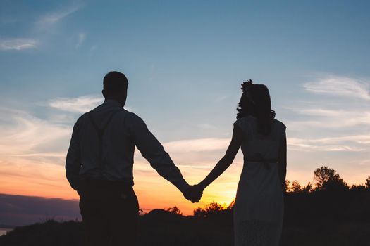 Loving couple together outdoor in mountains over scenic sunset sky background