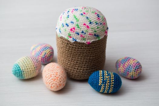 Knitted Easter eggs, chicken, cock on a white table.