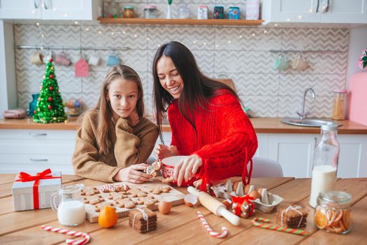 Happy family mother and daughter bake cookies for Christmas