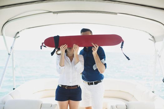A man and a woman on a yacht with a lifebuoy