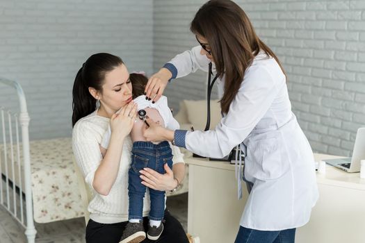 Professional general medical pediatrician doctor in white uniform gown listen lung and heart sound of child patient with stethoscope: Physician check up kid female after consult in hospital.
