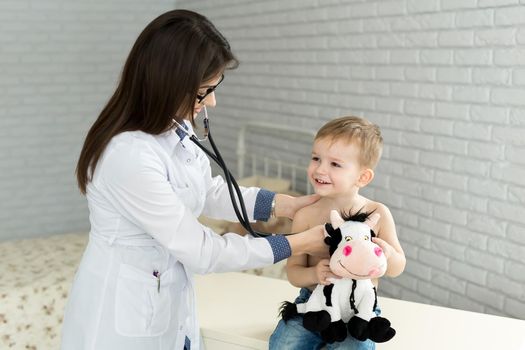 Professional general medical pediatrician doctor in white uniform gown listen lung and heart sound of child patient with stethoscope
