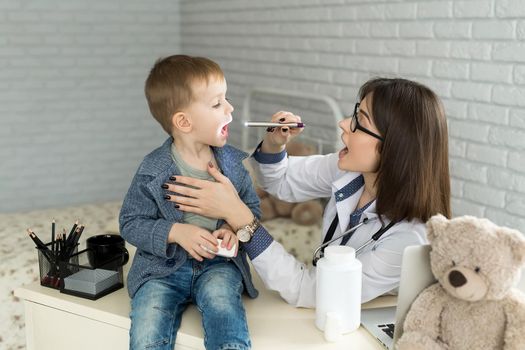 Doctor examine child's throat. Boy at pediatrician office