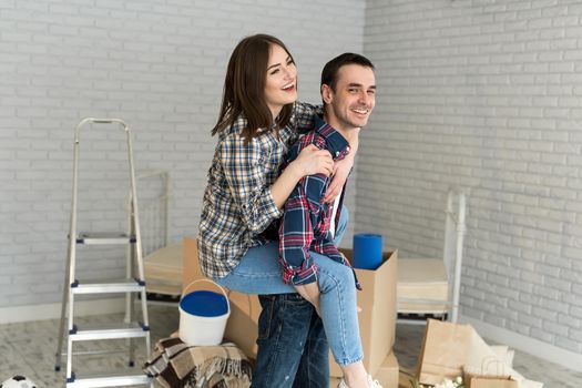 Happy couple is having fun in new house at moving day