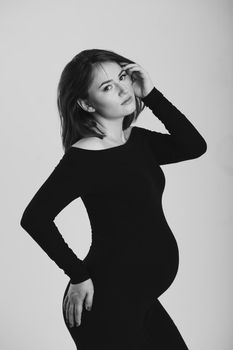 Black and white photo of a pregnant woman on a white background. Silhouette