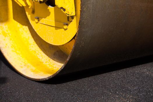 Pavement machine laying fresh asphalt or bitumen on top of the gravel base during highway construction.