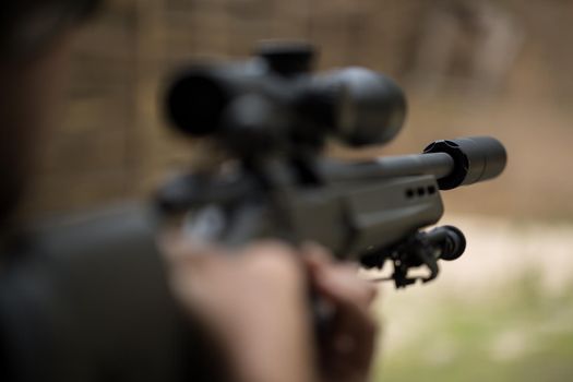 Sniper shooting rifle by looking through a scope