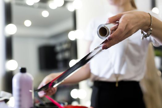 Barber holds the foil for hair coloring.