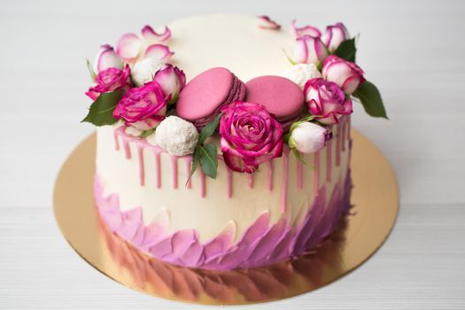 Cake with roses, sweets and lilac macaroons