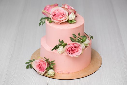 Delicate pink wedding cake with fresh flowers