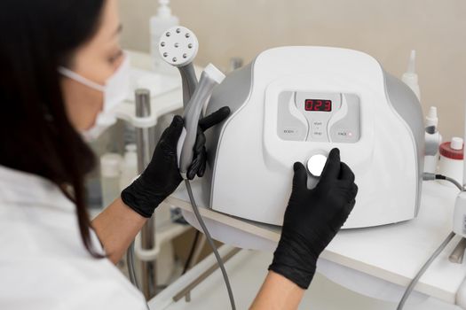 Close-up of a cosmetologist includes a mesotherapy medical device. Close-up of medical equipment in a cosmetology clinic. Skin care.