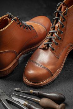 Handcrafted brown leather shoes with cobbler tools