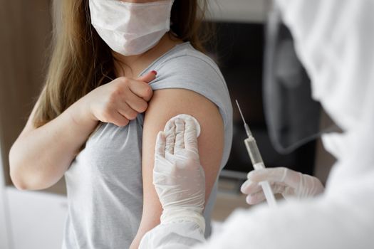 Doctor in personal protective suit or PPE inject vaccine shot to stimulating immunity of woman patient at risk of coronavirus infection. Coronavirus,covid-19 and vaccination concept