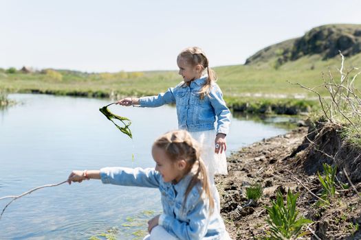 Two twin sisters have fun and play near the reservoir