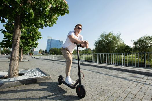 Man rides an electric scooter around the city.