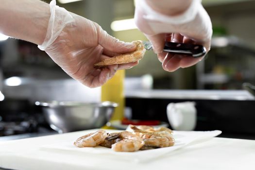 Chef cuts the shrimp. Concept of mediterranean cuisine