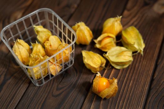 Photo of yellow physalis on a wooden background.