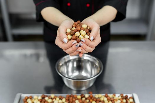 Pastry chef holds a lot of hazelnuts in his hands