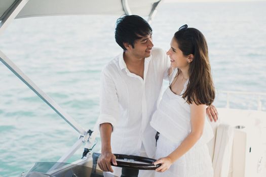 Young couple navigating on a yacht in Indian ocean.