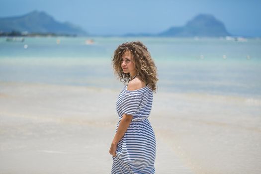 Beautiful girl in the Indian ocean with mountains in the background