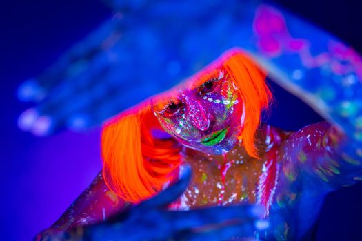Neon Woman dancing. Fashion model woman in neon light, portrait of beautiful model with fluorescent make-up, Art design of female disco dancer posing in UV, colorful make up.