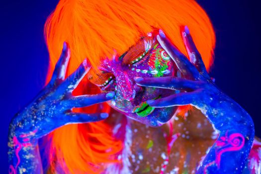 Neon Woman dancing. Fashion model woman in neon light, portrait of beautiful model with fluorescent make-up, Art design of female disco dancer posing in UV, colorful make up.