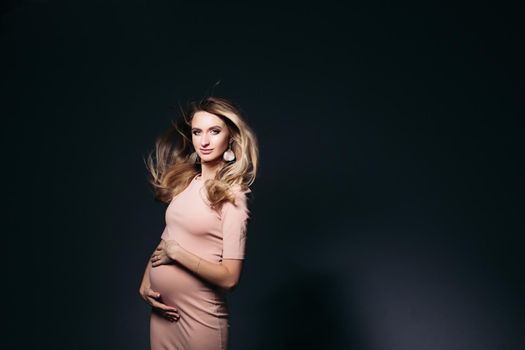 Windy effect on studio portrait of pregnant woman.