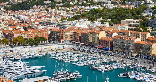 A lot o motor boats and luxury yachts are moored in port of Nice - France at sunny day, mooring ropes go into the amazing azure water, prows of motor boats in a row, roofs of orange color
