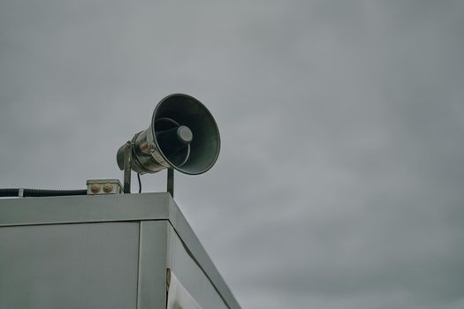 Megaphone on cloudy sky background.