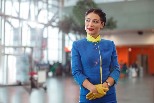 Female flight attendant standing in airport terminal