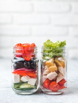 Caesar salad and Greek Salad in glass mason jar