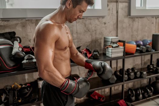 Athletic man preparing for box battle in the gym
